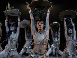 People on stage painted silver holding things over their head