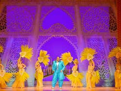 6 women dressed in yellow with a man dressed in blue in the middle