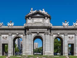 Puerta de Alcalá against a vibrant blue sky on a sunny day